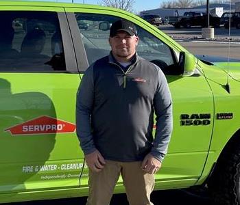 Picture of John Peters, male employee in front of green vehicle